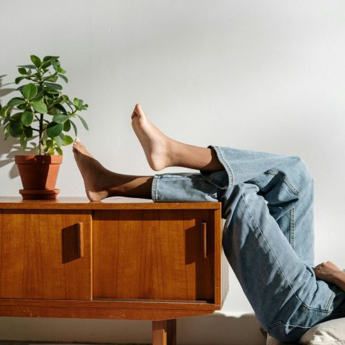 pexels-photo-4505458-4505458 Casual lifestyle scene with bare feet and denim in a cozy interior.